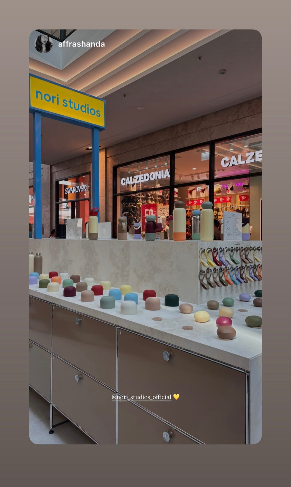 The nori studios store front with a display of caps and boots in every colour