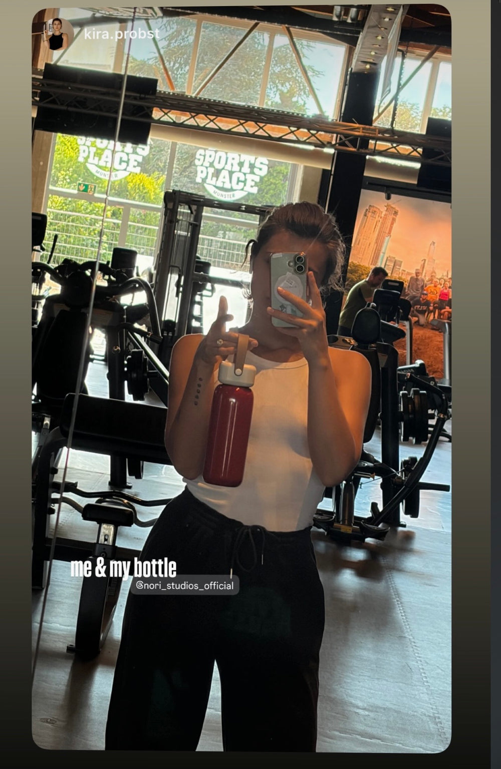Gym mirror selfie holding a red nori bottle