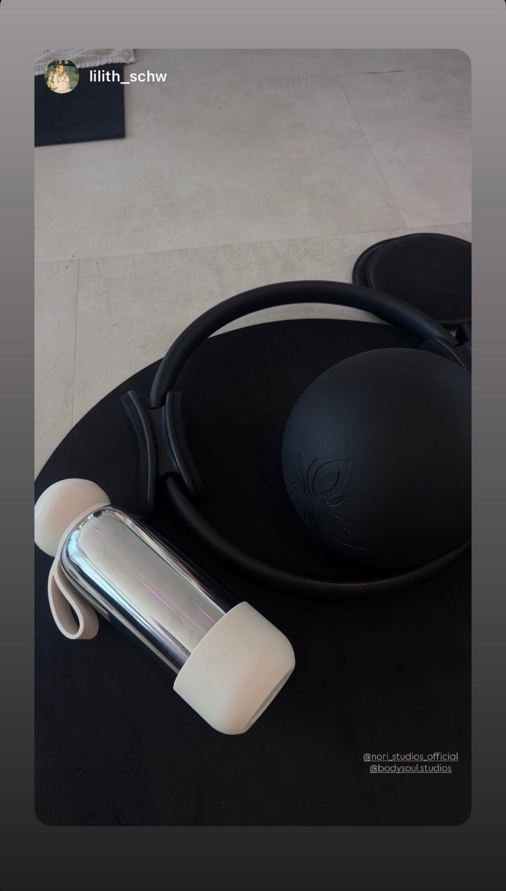 Chrome nori bottle with a white boot beside a pair of headphones