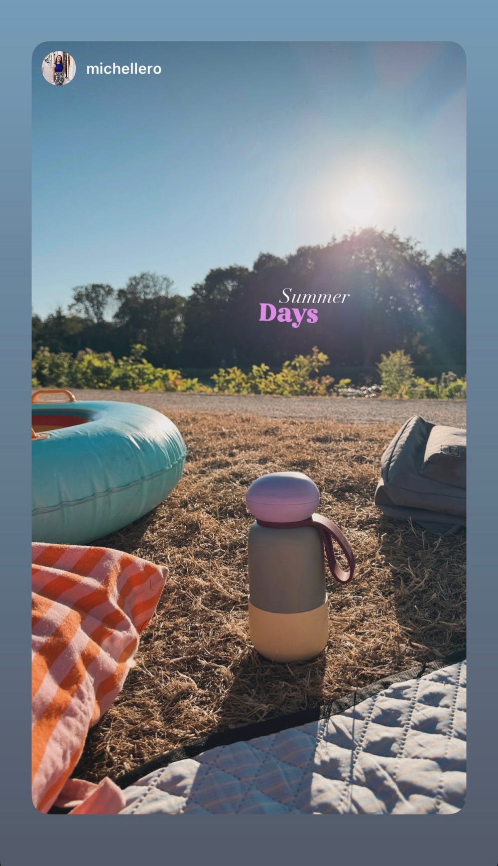 Lilac nori bottle on a picnic blanket in a summer field
