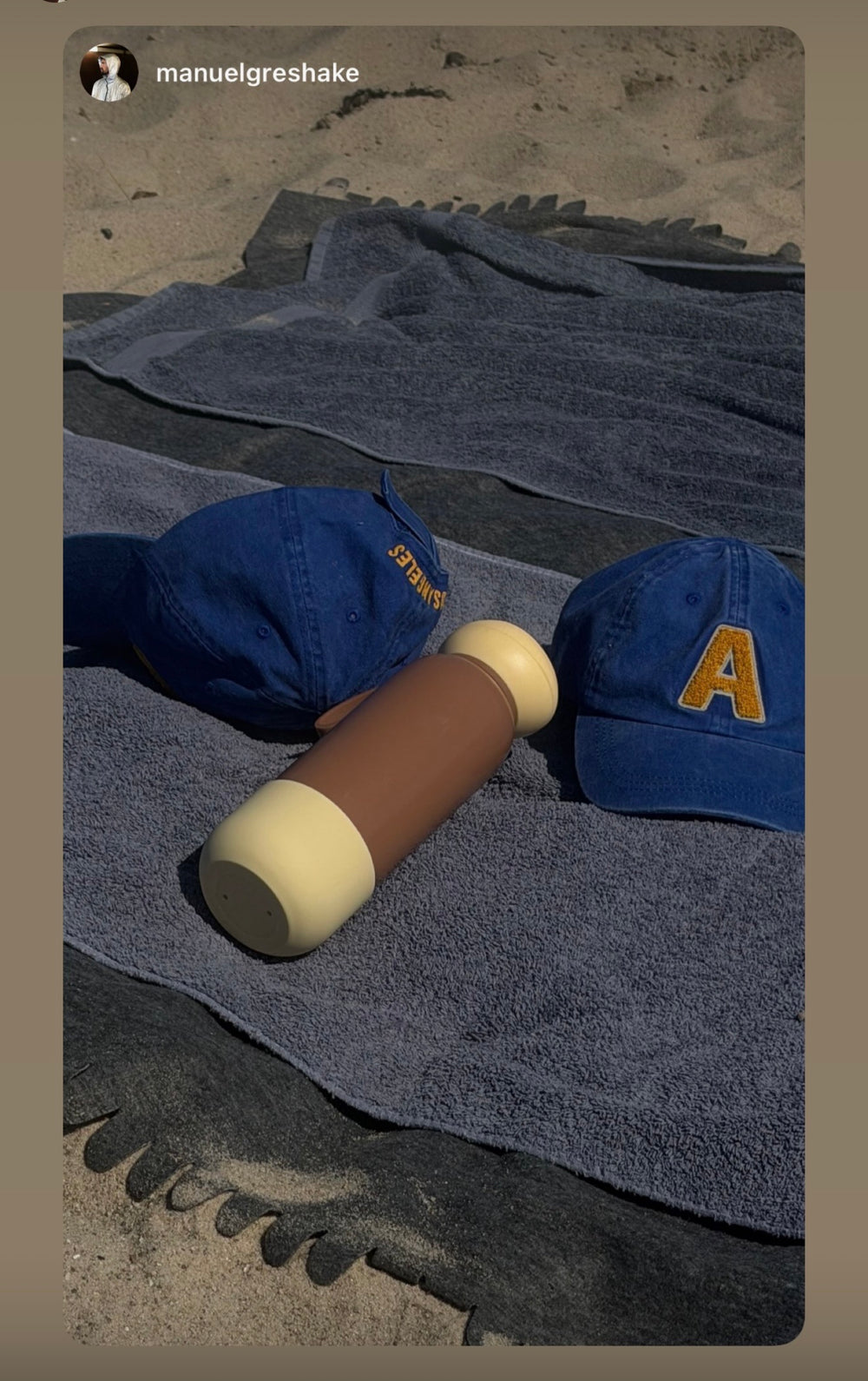 Brown and cream nori bottle on a beach towel with two caps