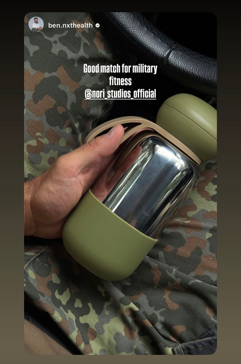 Chrome nori bottle with an olive boot, held against camouflage fabric